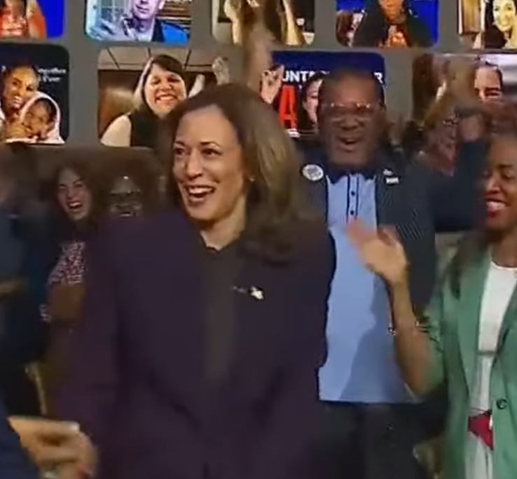 Michelle Higgs appears on the video wall as Kamala Harris enters the studio in the Unite for America event hosted by Oprah Winfrey.